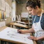 Étudiante en mise à niveau arts appliqués dessinant des formes architecturales dans un atelier scolaire