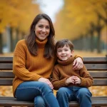 Une femme et son filleul assis ensemble sur un banc de parc en automne, souriant chaleureusement